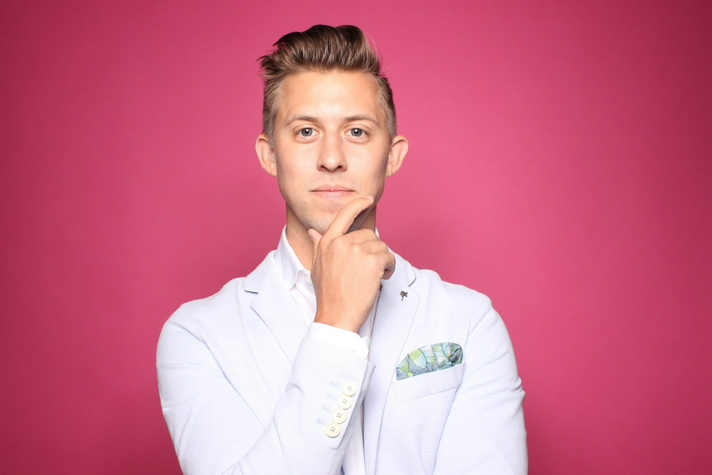 Marcus Adeyemi in a light jacket against a pink wall